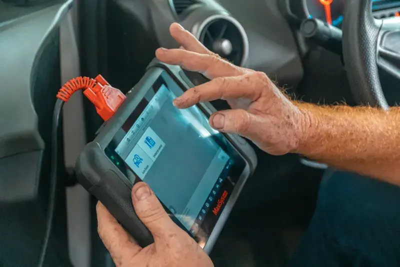 Technician using a diagnostic scan tool on a vehicle at FastLane Mechanics in Mississauga