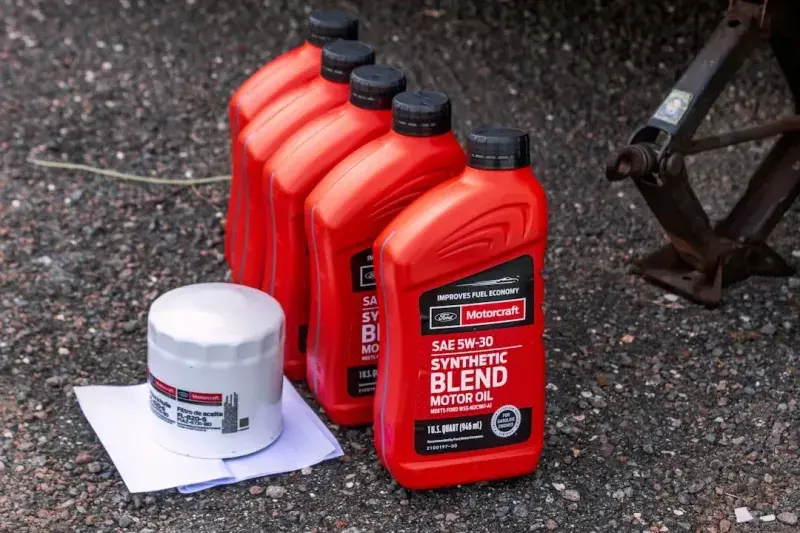 Bottles of synthetic blend motor oil beside a new oil filter