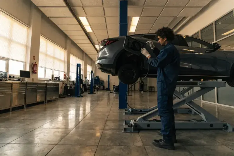 Do electric cars need maintenance: a technician servicing an electric vehicle in a Mississauga workshop